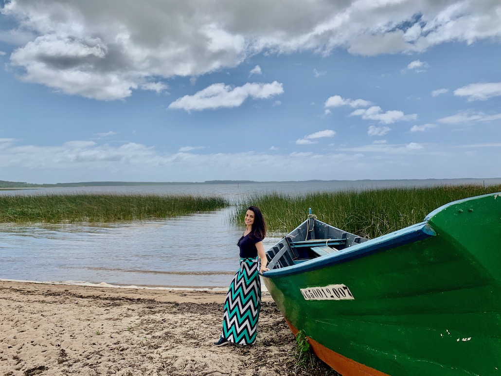 mulher em frente a barco na praia do jacarezinho