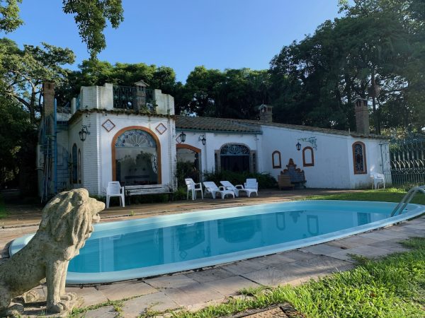 piscina com cadeiras e uma casinha ao fundo