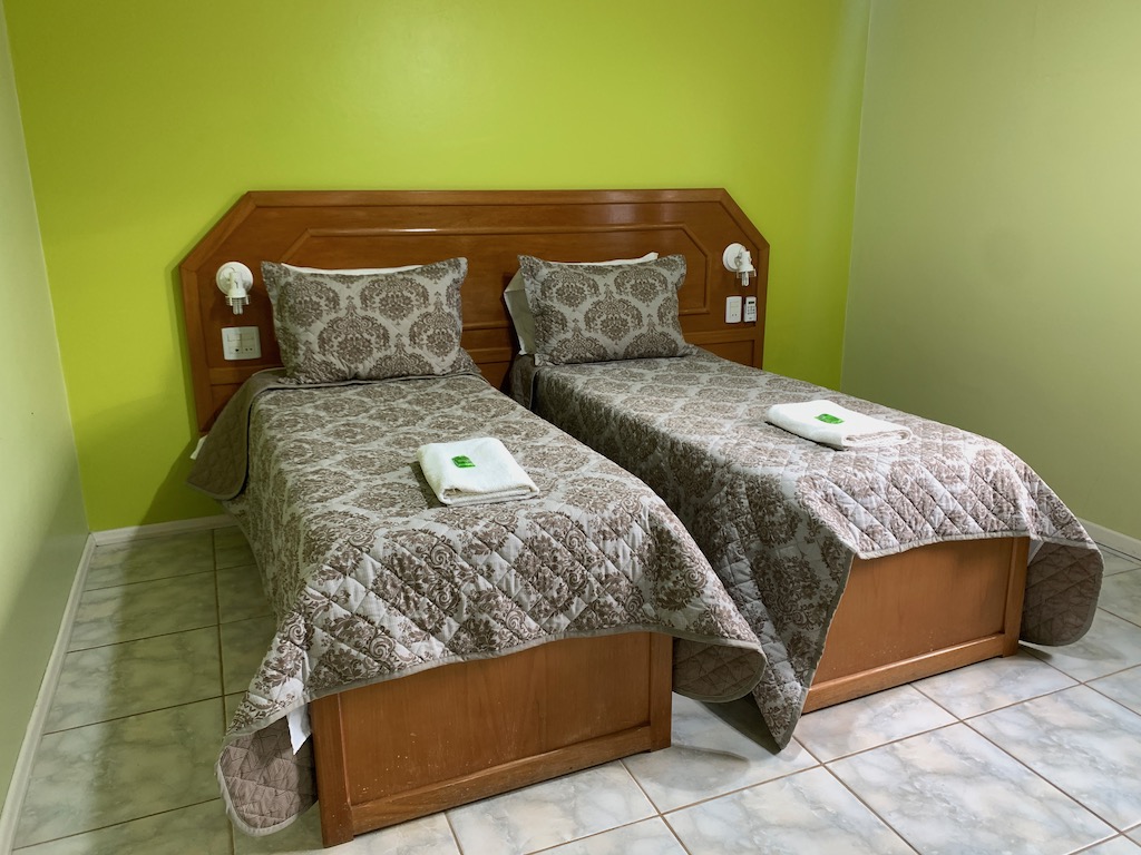 duas camas de solteiro em frente a parede verde