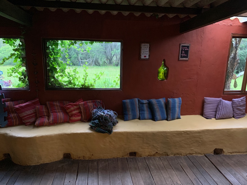ambiente interno com almofadas e janelas com vista para o verde