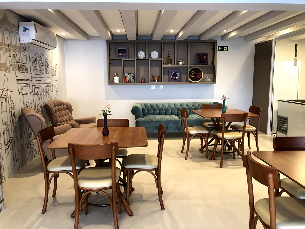 parte interna da loja de trufas, com cadeiras, mesas , sofá e parede com desenhos