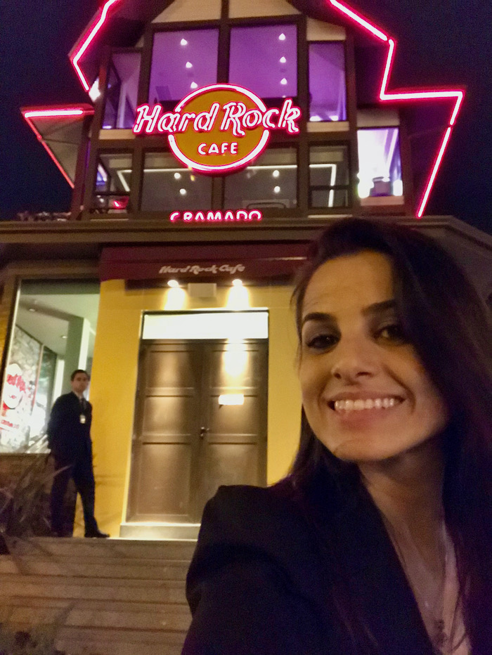 fachada do Hard Rock Cafe à noite, com iluminação em vermelho e amarelo