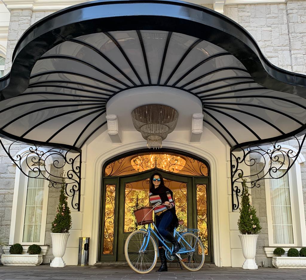 pessoa em uma bicicleta retrô na frente de um hotel
