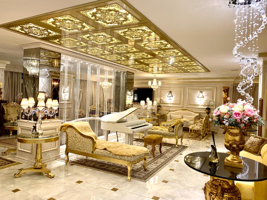 parte interna do hotel Colline de France, com sofás, piano, lustres de cristal e luzes intensas