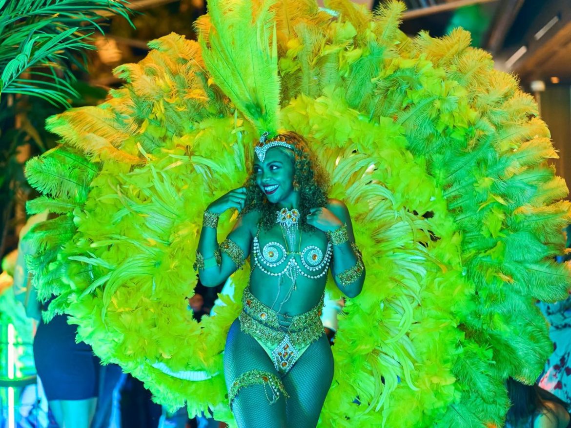 Na foto uma mulher exibe suas roupas carnavalescas verde limão